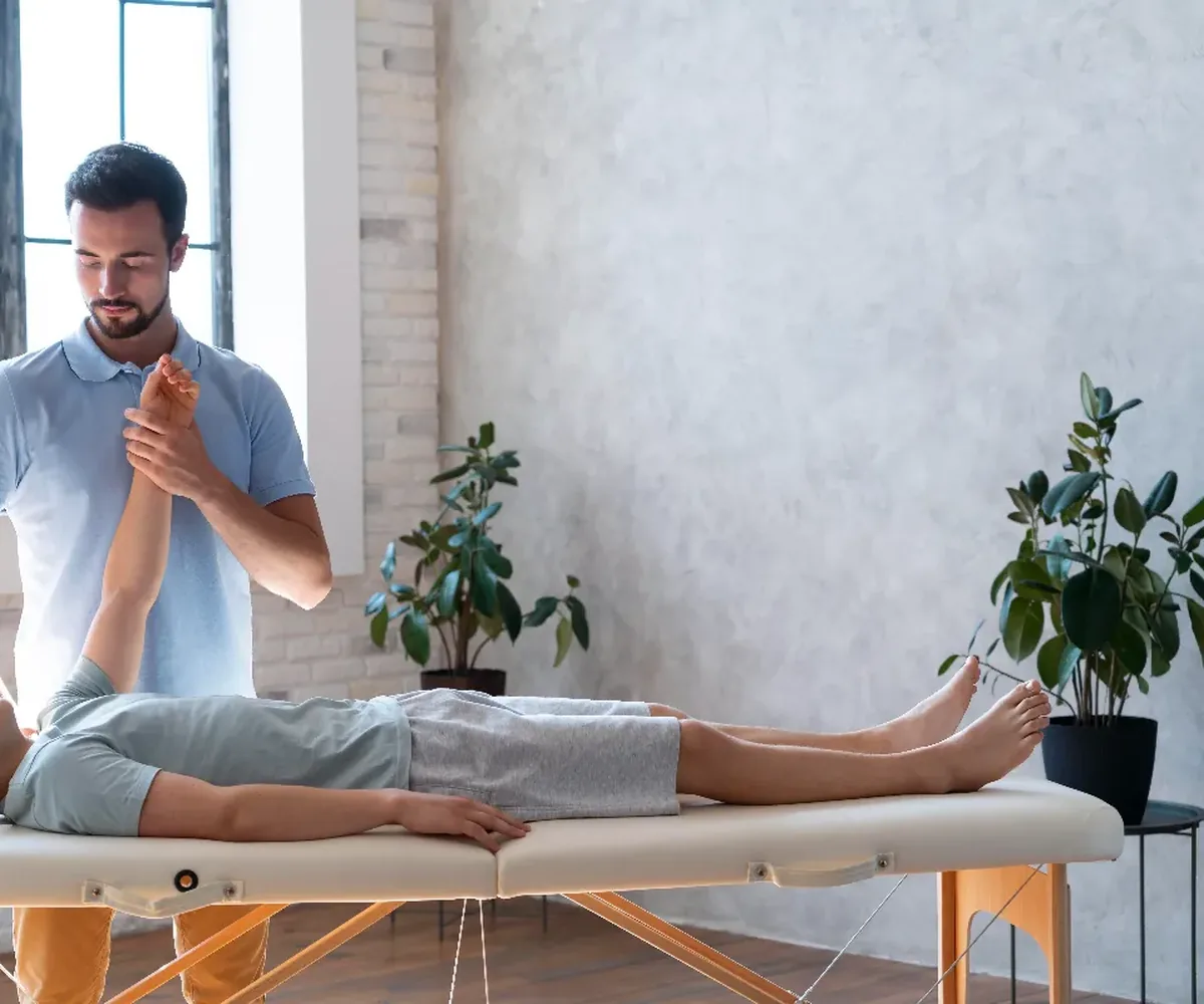A physical therapist working hands-on through a patient&rsquo;s restricted joint