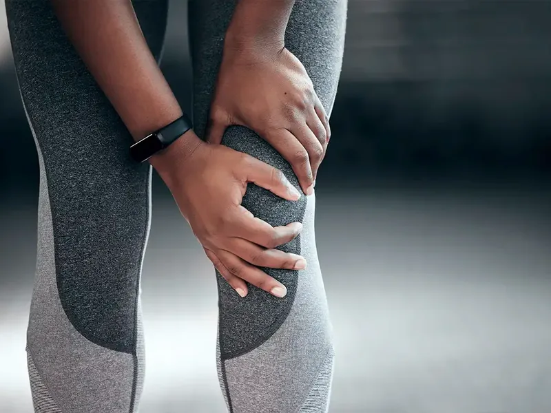 Two hands wrapped around a knee that has given out