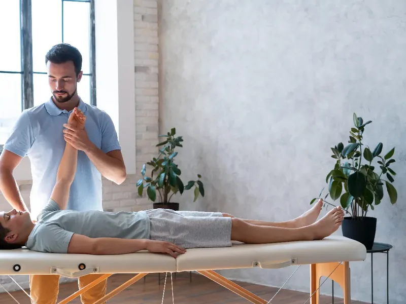 Doctor of Physical Therapy using hands-on manual therapy techniques with a patient