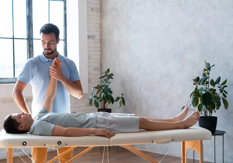 A physical therapist working hands-on through a patient&rsquo;s restricted joint